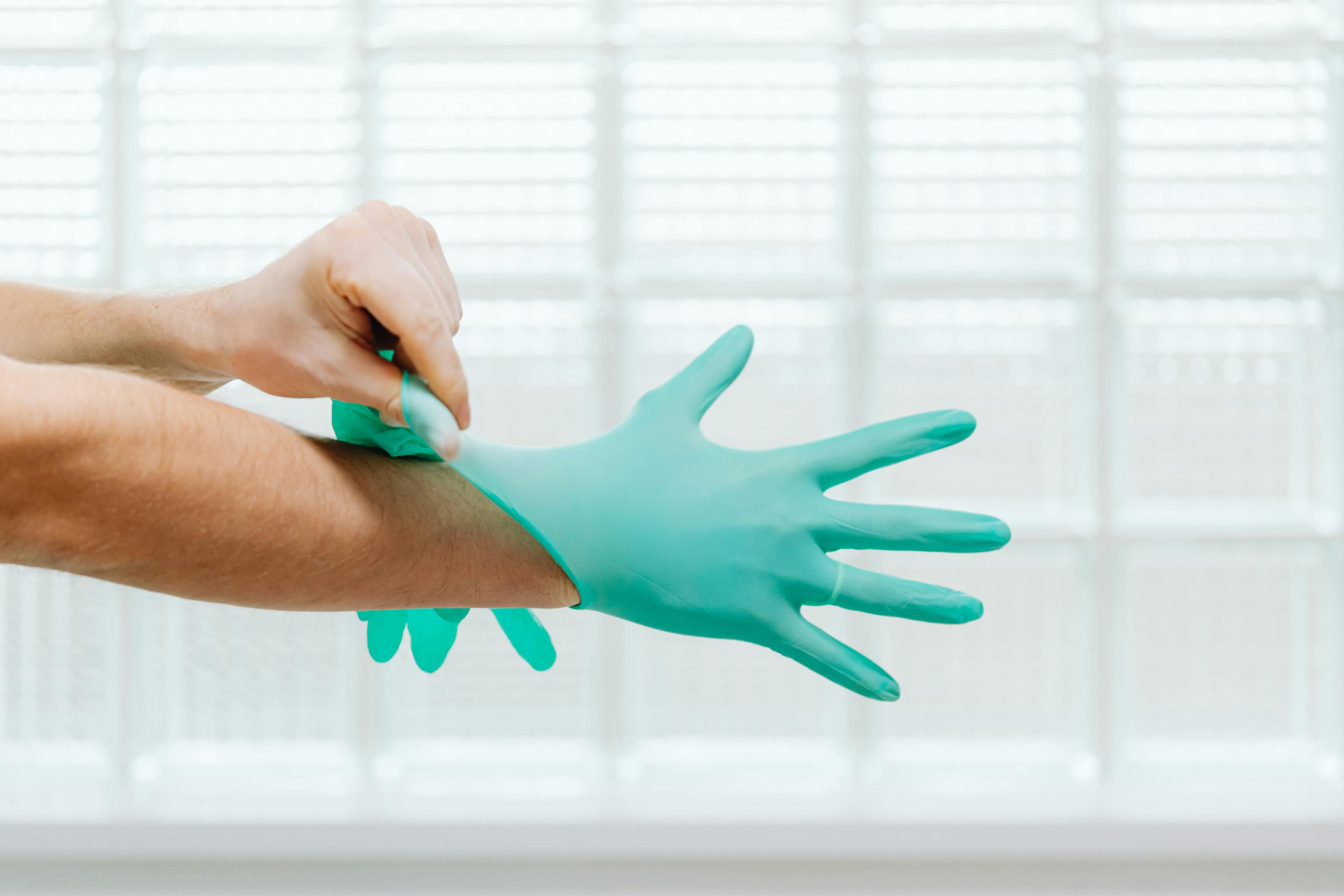 Gloved hands with PPE used in bloodborne pathogens training.